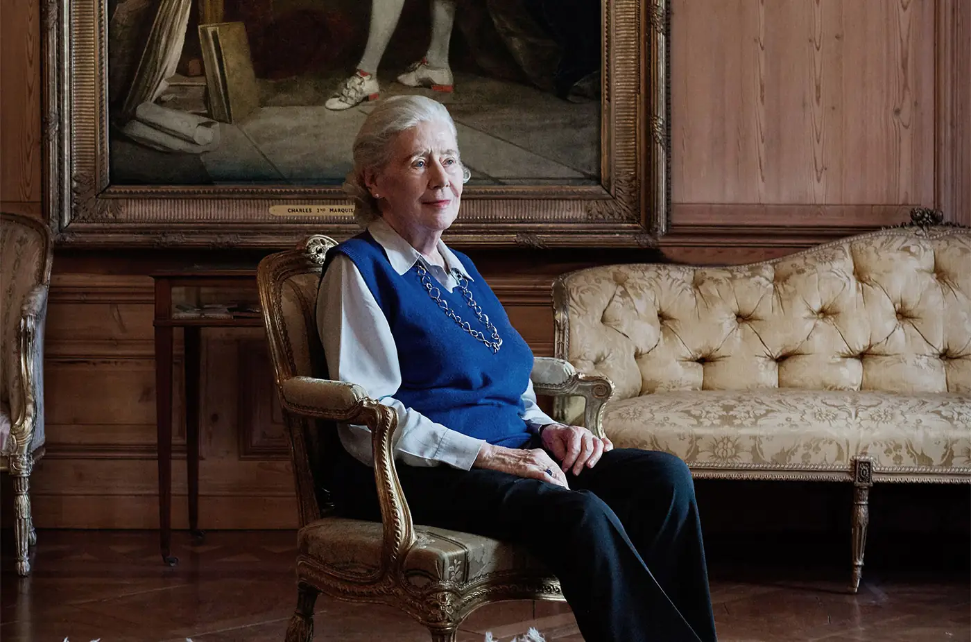 Environmental portrait of a woman seated in a panelled room